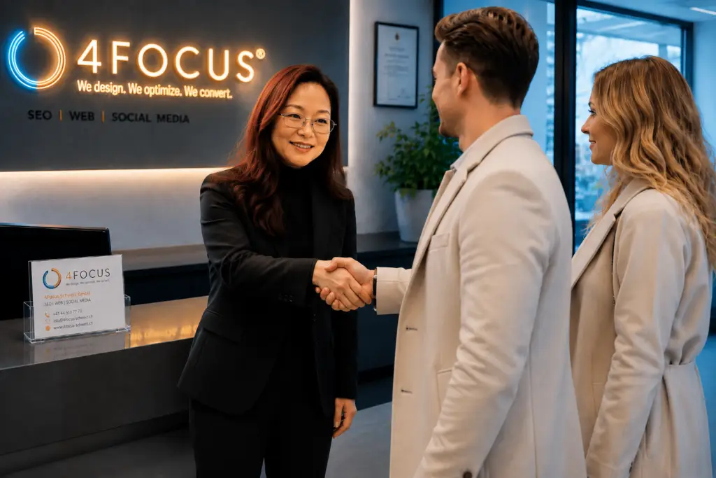 Two professionals shake hands at a reception desk in a modern office, with a 4FOCUS sign in the background.
